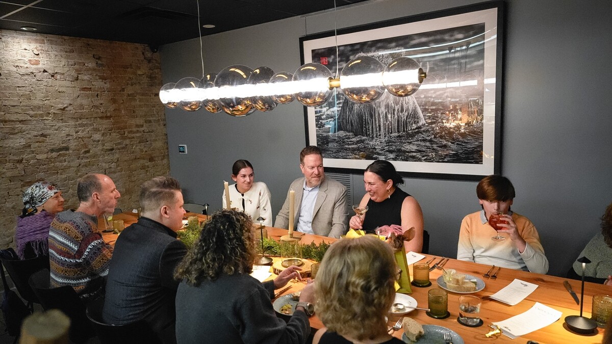 Group gathered around table earing, drinking, and talking